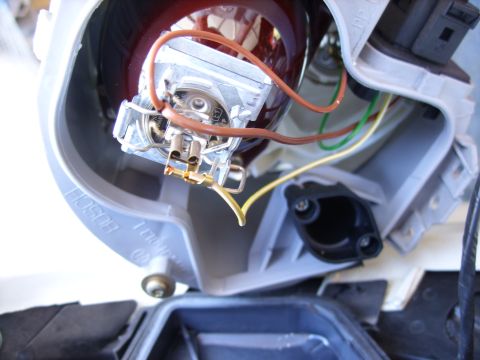 2003 Volkswagen Beetle - Close-up of a vehicle's headlight assembly, revealing internal wiring and a bulb connector.