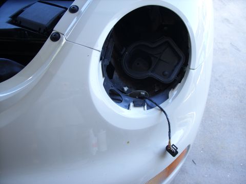 2003 Volkswagen Beetle - The front headlight assembly has been removed from this white vehicle, exposing the wiring harness.