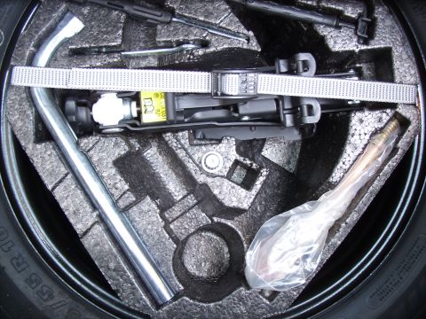 2003 Volkswagen Beetle - Spare tire well contains jack, lug wrench, and other tools for roadside emergencies.