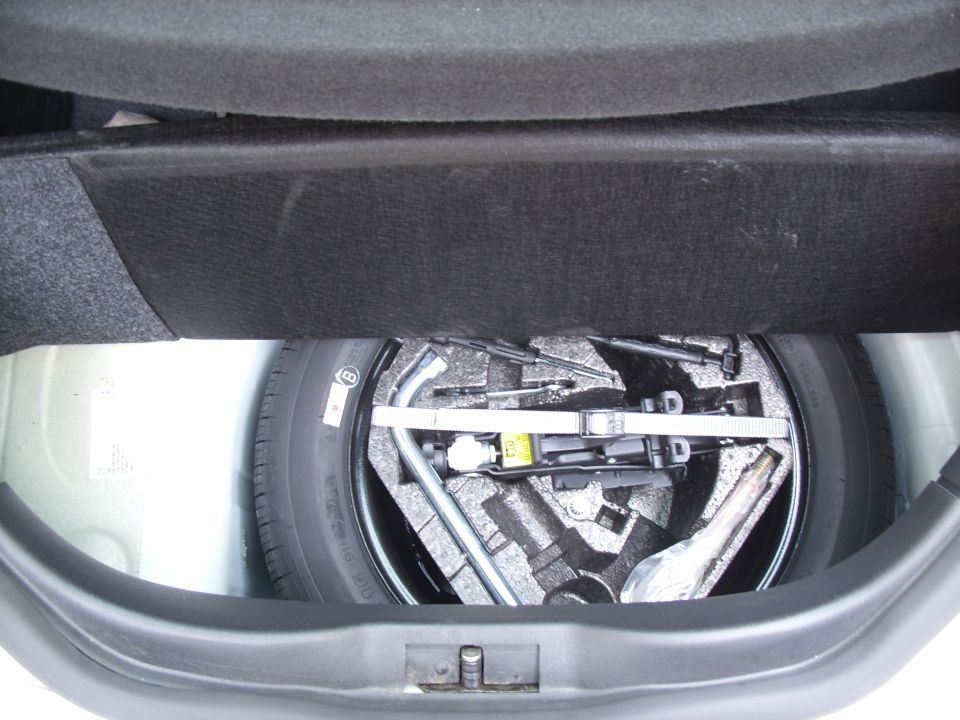 Trunk spare tire well with scissor jack and tools in foam tray