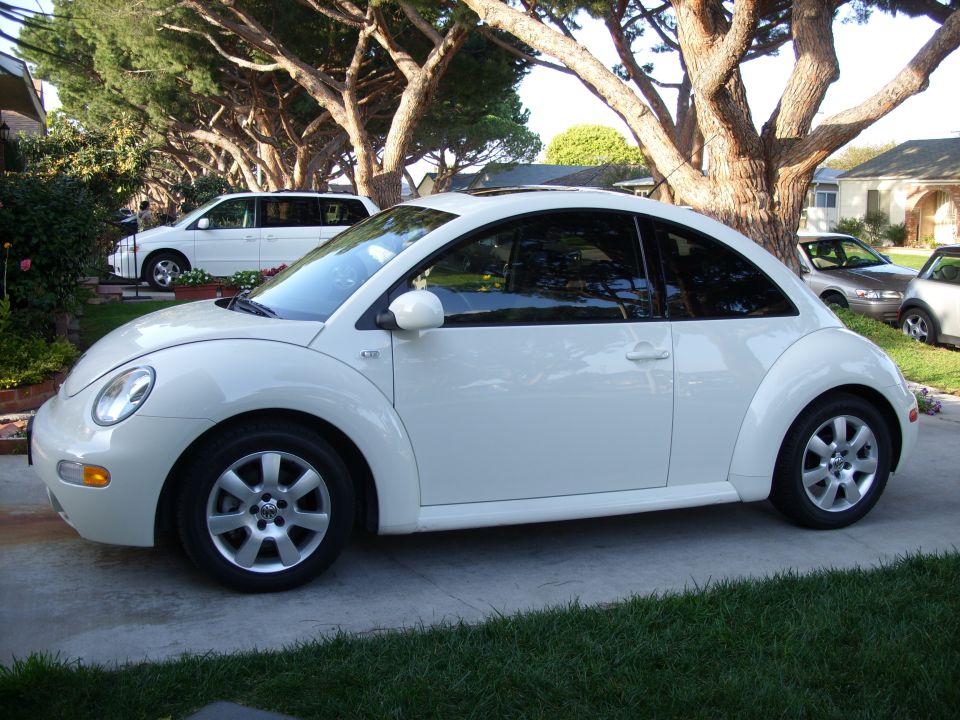 White 2003 Volkswagen Beetle parked on a driveway, side view