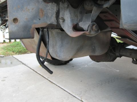1986 Ford Bronco - Close-up of a vehicle's undercarriage, focusing on the gas tank and suspension system.