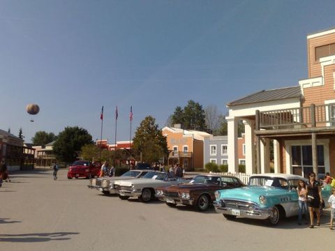 1991 Ford LTD Crown Victoria - Several vintage cars are parked in front of a themed building.