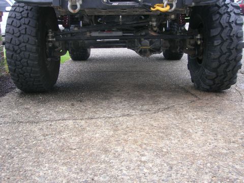 1996 Ford Bronco - The undercarriage of a modified off-road vehicle is shown from a low rear angle.