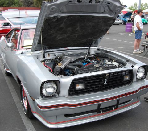 1978 Ford Mustang II - Silver coupe from the 1970s with hood open, revealing the engine bay. Red pinstripes accent the bodywork.