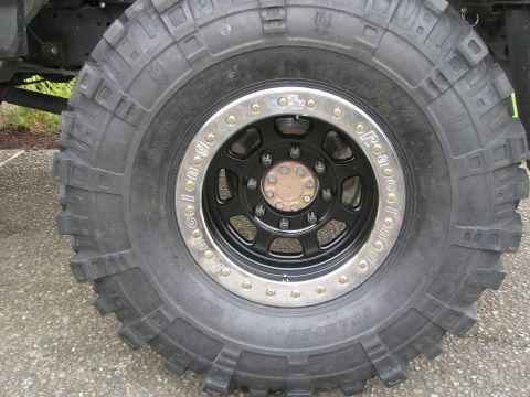 1996 Ford Bronco - Straight-on shot of a Super Swamper Bogger 16/40-17 tire mounted on a black eight-lug wheel with a polished TrailReady beadlock ring, sidew…