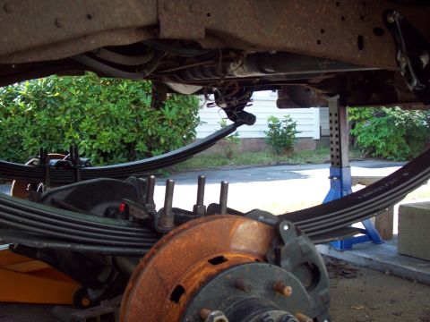 1989 Ford F-150 - The underside of a truck is shown, focusing on the leaf springs and brake assembly, indicating repair or modification work.