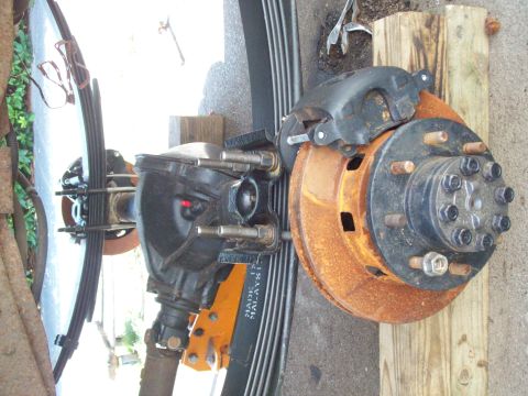 1989 Ford F-150 - Close-up of a vehicle's rear axle assembly, showing the brake components and leaf springs.