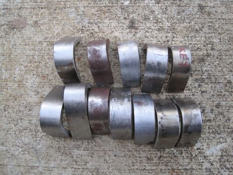 1995 Ford F-150 - Several metal parts are laid out on a concrete surface. One part has red writing on it.