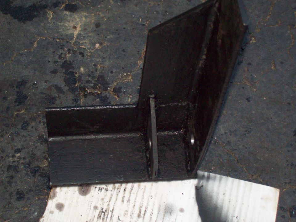 Black-painted welded steel bracket on a concrete floor