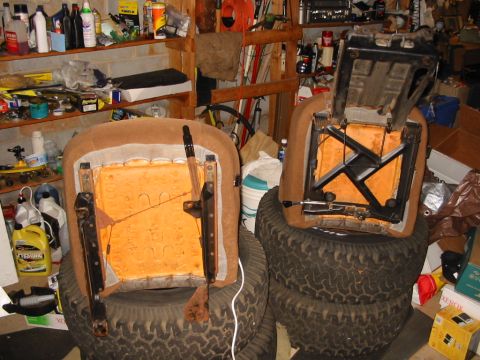 1988 Ford Bronco - Car seats are shown disassembled and stored on tires in a garage setting.