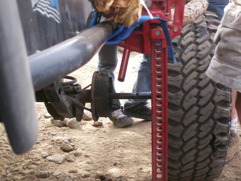 1993 Ford Bronco - A hi-lift jack is being used to lift a vehicle's axle during off-road maintenance.