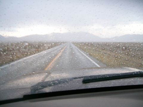 1993 Ford Bronco - View from inside a vehicle on a rainy day, looking out at a long, wet highway.