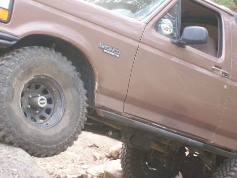 1993 Ford Bronco - This 1993 Ford Bronco is captured mid-adventure, navigating rocky terrain.