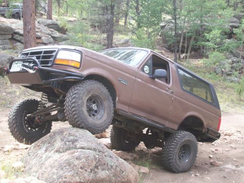 1993 Ford Bronco - Brown 1993 Ford Bronco navigating rocky terrain during an off-road excursion.