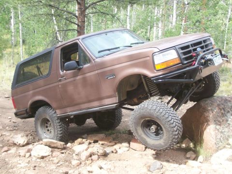 1993 Ford Bronco - This 1993 Ford Bronco is navigating a rocky trail with its tires on large boulders.