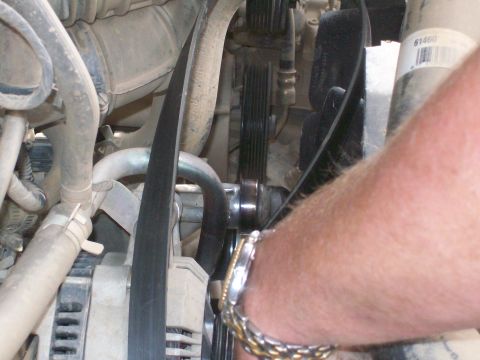 1993 Ford Bronco - Close-up view of a vehicle's engine bay, showing various components and a person's arm.