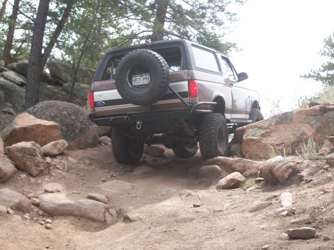 1993 Ford Bronco - This Ford Bronco is navigating a challenging rocky terrain on an off-road trail.