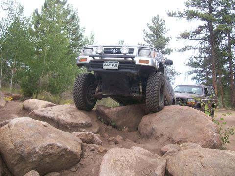 1993 Ford Bronco - Toyota pickup truck on a rocky trail with another SUV in the background.