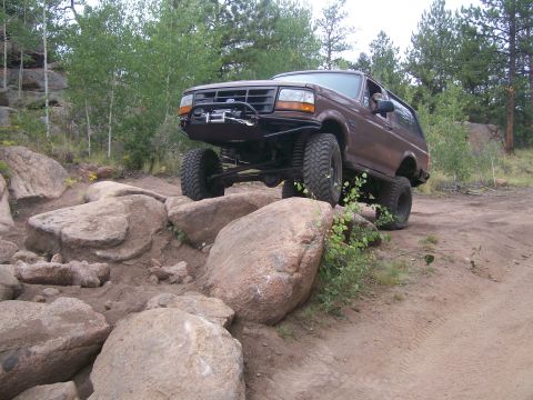 1993 Ford Bronco - This modified 1993 Ford Bronco navigates a challenging off-road course with large boulders.