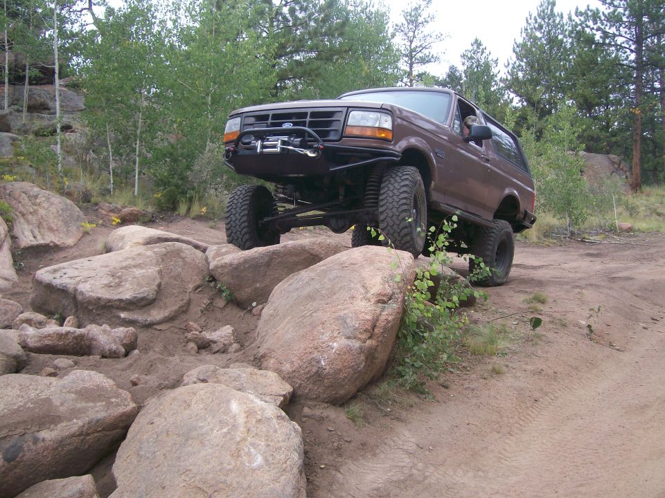 Brown 1993 Ford Bronco climbing rocky terrain