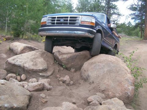 1993 Ford Bronco - Ford truck attempting to clear large rocks on an off-road trail.
