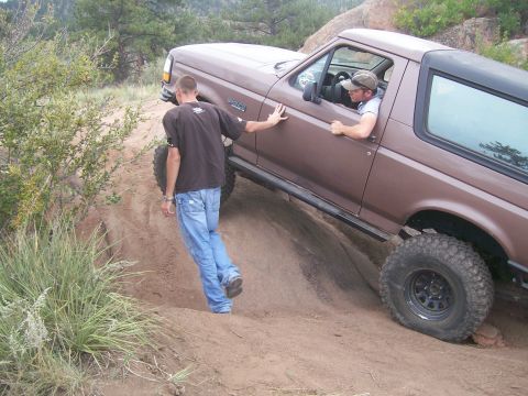 1993 Ford Bronco - Bronco climbing a rocky, off-road trail with a spotter providing guidance.