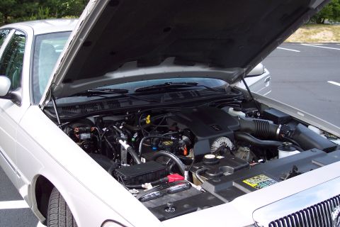 2001 Ford Crown Victoria - Silver 2004 Mercury Grand Marquis engine bay shown with the hood raised.