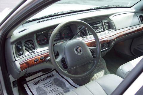 2001 Ford Crown Victoria - The interior of a Mercury Grand Marquis shows the dashboard, steering wheel, and passenger seat.