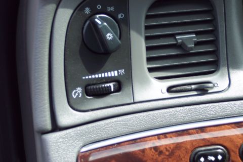 2001 Ford Crown Victoria - Close-up of the dashboard showing the headlight switch, dimmer control, and air vent.