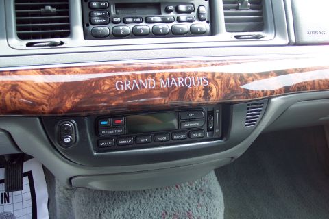 2001 Ford Crown Victoria - The interior dashboard features wood grain trim and climate controls.