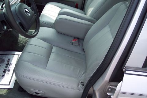 2001 Ford Crown Victoria - Interior view of a car, showing the front seats and steering wheel. A floor mat with text is visible.