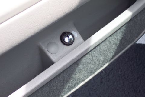 2001 Ford Crown Victoria - Close-up of a car's glove compartment lock and a small button.