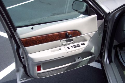2001 Ford Crown Victoria - The interior door panel features wood grain trim and power window controls.