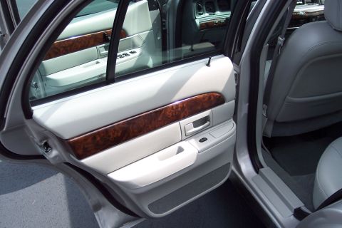 2001 Ford Crown Victoria - Interior of a car showing the door panel and seats, with wood grain accents.