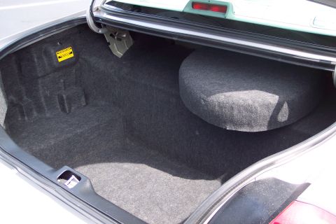 2001 Ford Crown Victoria - The interior of a car trunk is shown, revealing the spare tire compartment and carpeting.
