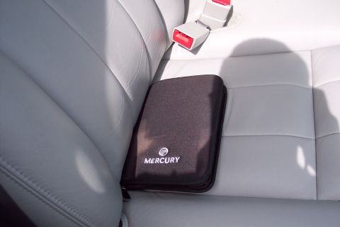 2001 Ford Crown Victoria - Manual case with Mercury logo rests on the back seat of a car.