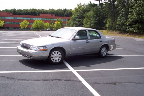 2001 Ford Crown Victoria - Silver Mercury Grand Marquis parked in a lot.