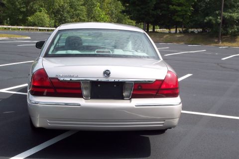 2001 Ford Crown Victoria - Rear view of a silver Mercury Grand Marquis parked in an empty lot.