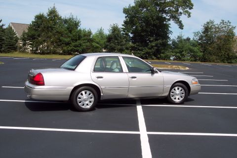 2001 Ford Crown Victoria - Silver sedan parked in a lot. The vehicle is a 2004 Mercury Grand Marquis.