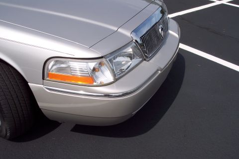2001 Ford Crown Victoria - Front corner of a silver Mercury Grand Marquis, showing the distinctive chrome grille and headlights.