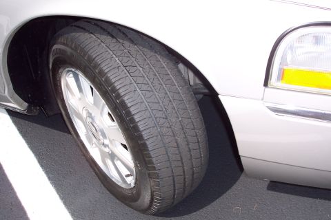 2001 Ford Crown Victoria - Front wheel and fender detail of a car.