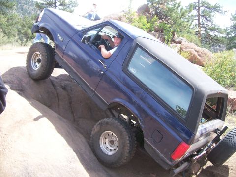 1993 Ford Bronco - This 1993 Ford Bronco is shown tackling a challenging off-road course with steep inclines and large rocks.
