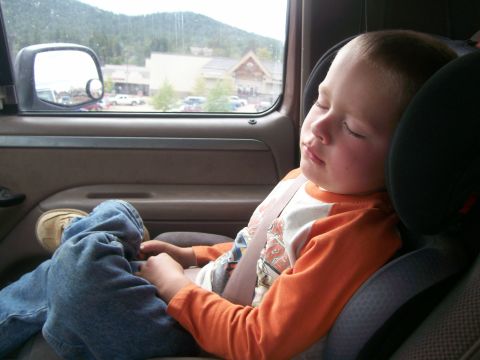 1993 Ford Bronco - A young child sleeps soundly in a car seat while traveling, with a scenic view outside.