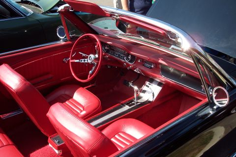 2001 Ford Crown Victoria - The vibrant red interior of a classic 1965 Ford Mustang convertible is displayed, with another vehicle visible in the background.