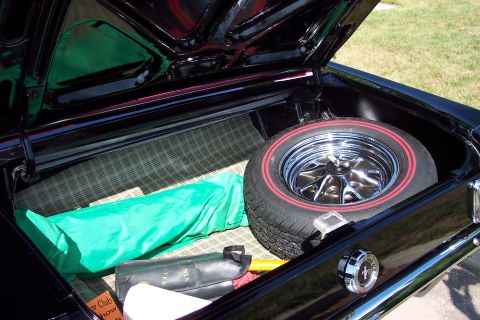 2001 Ford Crown Victoria - Car trunk interior with spare tire, green cover, and tool kit visible.