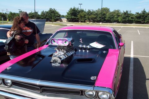 2001 Ford Crown Victoria - A heavily modified muscle car with a vibrant pink and black paint scheme is displayed at an outdoor event.