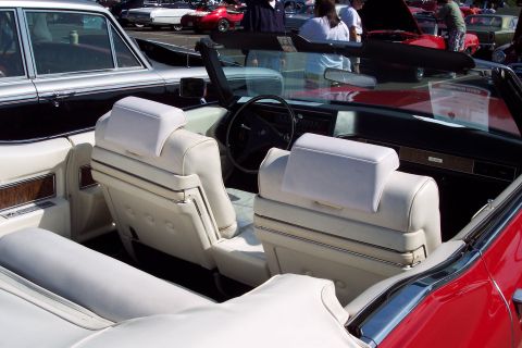 2001 Ford Crown Victoria - Interior of a classic convertible with white seats and wood trim, seen at a car show.