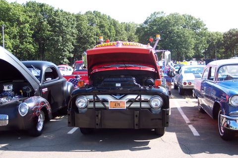 2001 Ford Crown Victoria - Front view of a 1956 Ford F-series tow truck at a car show with its hood open.