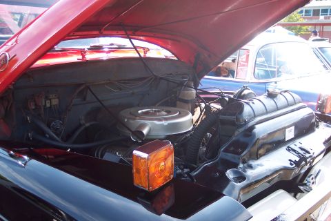 2001 Ford Crown Victoria - The engine bay of a vintage truck is displayed with the hood up, revealing its mechanical components.